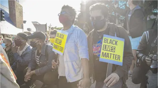  ?? ANTHONY VAZQUEZ/SUN-TIMES PHOTOS ?? ABOVE: A couple holds hands while holding Black Lives Matter signs during a protest on Halsted Street in Lake View on Sunday. RIGHT: Zola, an activist, reads a poem to the crowd about injustice.