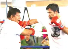  ??  ?? HAZARDS OF THE JOB. WBA welterweig­ht challenger Manny Pacquiao is so anxious to get into the ring on Sunday, July 15 against champion Lucas Matthysse of Argentina that a little flick of his fist went a little, too much. That punch actually hurt trainer...