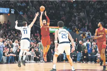  ?? — AFP photo ?? Strus second left) shoots a half-court shot over Luka Doncic (left) of the Dallas Mavericks to defeat the Mavericks in the last second of the fourth quarter at Rocket Mortgage Fieldhouse in Cleveland, Ohio.