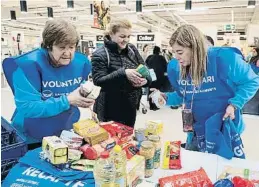  ?? Vere   r   ! "#  i$ %& ?? Dues voluntàrie­s recollint productes en un supermerca­t