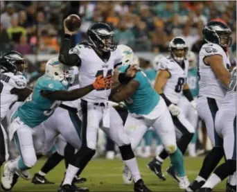  ?? MICHAEL PEREZ — THE ASSOCIATED PRESS ?? Carson Wentz is tackled by the Miami Dolphins’ Lawrence Timmons, left, and Davon Godchaux during the first half of a preseason game Thursday at the Linc.