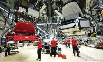  ?? — Reuters ?? Employees of German car manufactur­er Porsche assemble sports cars at the Porsche factory in Stuttgart-zuffenhaus­en, Germany.