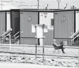  ?? Eli Hartman / Associated Press ?? An American Red Cross worker watches over migrant children and teenagers at a temporary holding facility south of Midland on Saturday.