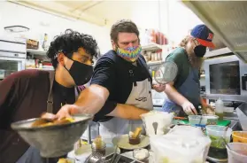  ?? Brittany Hosea-Small / Special to The Chronicle ?? Andrew Greene, coowner of Abstract Table, works with line cook Jessie Romero (left) and sous chef Will Crosby (right) in the restaurant’s kitchen.