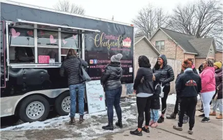  ?? ROBERT KILLIPS/LANSING STATE JOURNAL VIA USA TODAY NETWORK ?? People brave the cold for Everything is Cheesecake’s food truck.