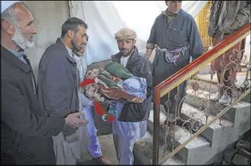  ?? Rahmat Gul The Associated Press ?? Relatives carry the body of a boy killed in a mortar attack in Kabul, Afghanista­n. Mortar shells slammed into different parts of the Afghan capital on Saturday.