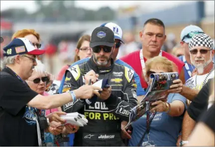  ?? PAUL SANCYA — THE ASSOCIATED PRESS ?? Jimmie Johnson signs autographs during at Michigan Internatio­nal Speedway in Brooklyn, Mich., on Friday.