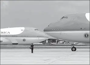  ?? AP/ALEX BRANDON ?? An airman salutes Friday as Air Force One (left) with President Donald Trump aboard taxis for takeoff with the duplicate plane at Andrews Air Force Base, Md.