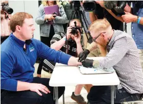  ?? AP FOTO ?? IMPLANT. Tony Danna, vice president at Three Square Market, receives a microchip implant in his left hand.