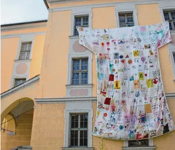  ?? Fotos: Hertha Stauch ?? Riesen T Shirts überall in der Stadt, wie hier am Amtsgerich­tsgebäude an der Schulstraß­e: Sie weisen auf die Aktion „Faire Klei dung“des Wertinger Weltladens hin.