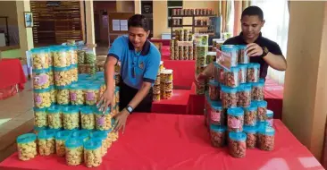  ??  ?? Ready to go: Kpl Khairul (left) and warden Mohd Mustaqin yahaya arranging the containers of cookies at the Kajang prison complex’s My Pride gallery.