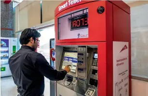  ?? —Photo by Neeraj Murali ?? A customer at the RTA Happiness Centre makes his transactio­n through a smart teller on the first day of the ‘Week without Service Centres’, which runs until October 25.