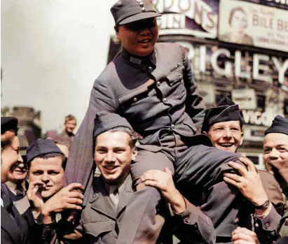  ??  ?? A member of the Chinese Military Mission is carried shoulder-high by a crowd in Piccadilly Circus in London on VJ Day