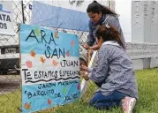  ?? Marina Devo / Associated Press ?? Schoolteac­hers hang a sign that reads “ARA San Juan, we wait for you” on a the fence at the naval base in Mar del Plata, Argentina, on Monday.