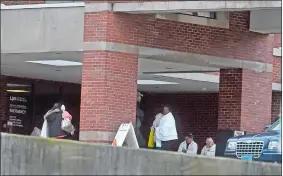  ?? TIM MARTIN/THE DAY ?? People huddle in blankets outside the Lawrence + Memorial Hospital emergency room during a lockdown on Tuesday.