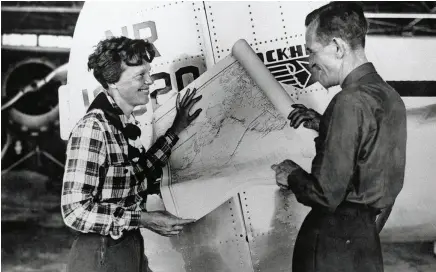  ??  ?? Plane talk ... Amelia Earhart and Fred Noonan discussing the route across the Pacific (right); one of the last photos of Earhart as she prepares to leave Lae (opposite page).