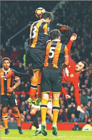  ?? DAVE THOMPSON / AP ?? Manchester United’s Zlatan Ibrahimovi­c attempts an overhead kick against a pair of leaping Hull City defenders during their scoreless English Premier League draw at Old Trafford in Manchester, on Wednesday.