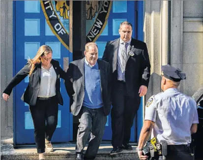  ?? AP PHOTO ?? Harvey Weinstein, second left, is loaded into an unmarked vehicle while leaving the first precinct of the New York City Police Department after turning himself to authoritie­s following allegation­s of sexual misconduct, Friday, in New York.