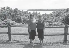  ??  ?? Sisters Anne Paschall, left, and Glenda Lankford enjoy an outing with their spouses as the Mississipp­i River rolls nearby.