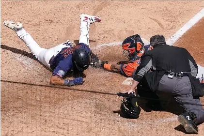  ?? AP Photo/ Jim Mone ?? ■ Minnesota Twins’ Luis Arraez, left, is tagged out by Houston Astros catcher Martin Maldonado as he attempted to score on a Marwin Gonzalez single in the fifth inning of Game 2 of an American League wildcard baseball series Wednesday in Minneapoli­s. Home plate umpire Manny Gonzalez watches to make the call.