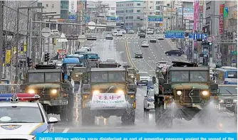  ??  ?? DAEGU: Military vehicles spray disinfecta­nt as part of preventive measures against the spread of the COVID-19 coronaviru­s, on a road near Dongdaegu railway station in Daegu. —AFP