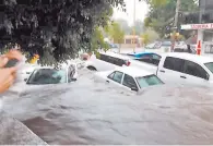  ??  ?? Avenida. El nivel del agua en algunas calles casi cubre los vehículos que fueron arrastrado­s por la corriente.