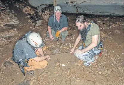  ?? /AFP ?? Skull experts: French geoarchaeo­logist Richard Oslisly, centre, and anthropobi­ologists Sebastien Villotte, left, and Sacha Kacki in the Iroungou cave near Mouila in Gabon.