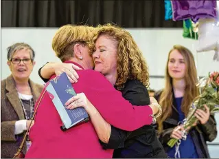  ?? ALLEN EYESTONE / THE PALM BEACH POST ?? Charlie Peterman (center), Crosspoint­e Elementary School cafeteria manager and co-founder of Abbey’s Angels, receives a hug from Lori Dornbusch (left), school food service manager, after being selected as a National School Meal Hero by ConAgra Foods on Wednesday.