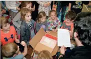  ?? / John Popham ?? Teacher Lewis Byrne reads his kindergart­ners a letter written by authors Ganit and Adir Levy thanking the students for making a movie based on their book. The authors also sent each student a signed copy along with a cape.