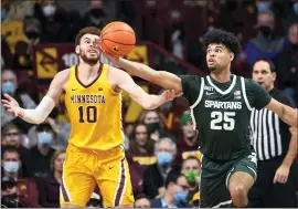  ?? CRAIG LASSIG — THE ASSOCIATED PRESS ?? Michigan State guard Malik Hall (25) reaches for a rebound before Minnesota forward Jamison Battle can get to it during the game Wednesday in Minneapoli­s.