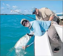  ?? [MICHAEL PEARCE/WICHITA EAGLE] ?? Fishing guide Rick Stanczyk holds a 60-pound tarpon caught by Brian Elliott near Islamorada in the Florida Keys on April 24. The area annually produces tarpon three times as big.
