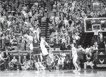  ?? K.C. ALFRED U-T ?? Utah State’s Sam Merrill takes the winning 3-pointer over San Diego State’s KJ Feagin to win the title.