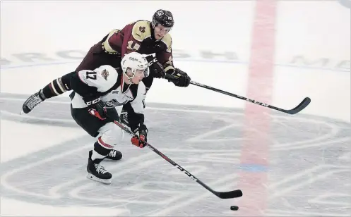  ?? TODD VANDONK/METROLAND ?? The Windsor Spitfires’ Igor Larionov skates the puck out of his own end with the Peterborou­gh Petes’ Nick Isaacson chasing him down in OHL action at the Memorial Centre on Saturday.