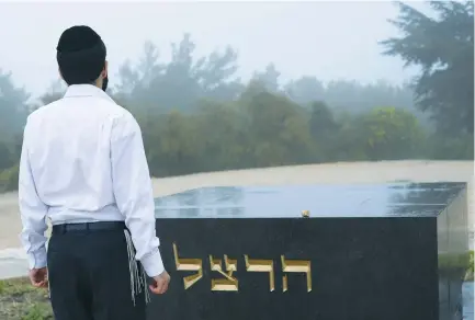 ?? (Zuzana Janku/Flash90) ?? A HAREDI man pays his respects at the grave of Theodor Herzl on Mount Herzl in Jerusalem.