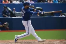  ?? MELISSA RENWICK/TORONTO STAR ?? Jose Bautista hits a two-run home run in the seventh inning on Monday.