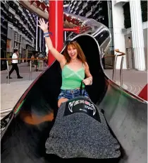  ?? ?? Sip, sliding away: Jo takes a tipple at the champagne bar and tries the 11-storey Venom Drop slide