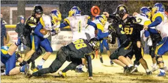  ?? PHOTO COURTESY SHELLEY WILLIAMS ?? Slippery footing. Prairie Grove defenders Elliot Chamberlai­n (88) and Jackson Diebold (61) try to stay on their feet while Blake Faulk (20) makes a tackle against Valley View. The Tigers were eliminated from the playoffs by the Blazers, 14-12, on...