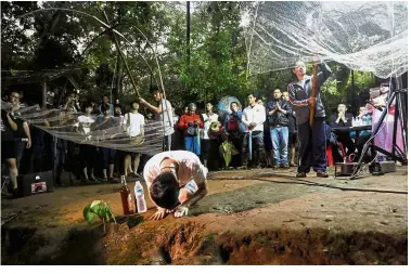  ?? — AFP ?? Seeking divine help: Relatives praying at the entrance of the cave in Chiang Rai province.