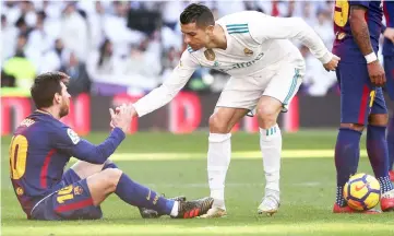  ??  ?? Real Madrid’s Cristiano Ronaldo (right) helps Barcelona’s Lionel Messi get back to his feet. — Reuters file photo
