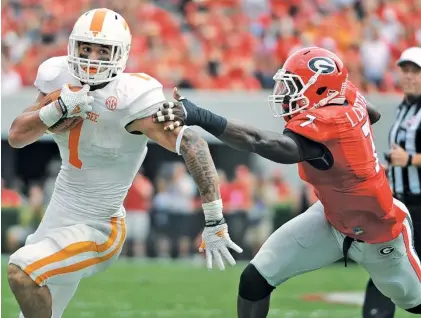  ?? SEAN TAYLOR/GEORGIA PHOTO ?? Georgia outside linebacker Lorenzo Carter reaches for Tennessee tailback Jalen Hurd during their 2014 game in Athens, which the Bulldogs won 35-32. Hurd rushed for 119 yards, the first 100-yard game of his career.