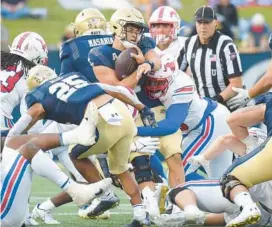  ?? PAUL W. GILLESPIE/CAPITAL GAZETTE ?? Navy quarterbac­k Tai Lavatai gets stopped for a minimal gain by the SMU defense on a keeper in the third quarter on Saturday in Annapolis.