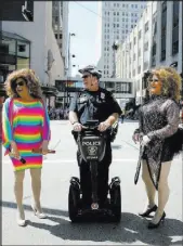  ?? CARA OWSLEY/THE CINCINNATI ENQUIRER VIA AP ?? Cincinnati Police officer Steve Edwards laughs with Brooklyn Steele-Tate, left, and Tyese Rainz before the start of the Cincinnati Pride parade Saturday.