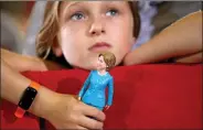  ?? REUTERS ?? Nine- year- old Belle Shefrin holds a doll of US Democratic presidenti­al nominee Hillary Clinton while listening to Clinton speak at a campaign rally in Akron, Ohio on Monday.