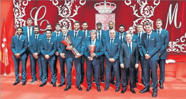  ??  ?? CAMPEONES. Los jugadores del Real Madrid y Florentino Pérez posan con Ángel Garrido, presidente de la Comunidad de Madrid, ayer en la celebració­n de la Décima.