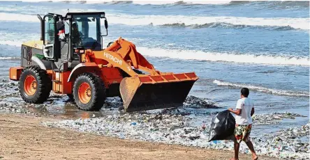  ?? Reuters/AFP ?? A worker in a bulldozer shoveling large amounts of marine waste to one spot as collectors clear the mostly plastic refuse at Kuta Beach in Bali.—