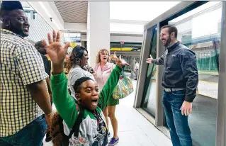  ?? GREG LOVETT / THE PALM BEACH POST ?? Brightline’s president and COO, Patrick Goddard, welcomes the first passengers arriving in Miami on Saturday’s inaugural train service from West Palm Beach.