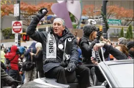  ?? BOB ANDRES / AJC 2018 ?? Atlanta United owner Arthur Blank tosses souvenir soccer balls to fans along the route in downtown Atlanta after the team won the 2018 MLS Cup.