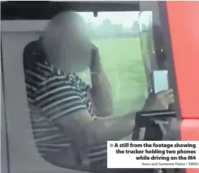  ?? Avon and Somerset Police / SWNS ?? A still from the footage showing the trucker holding two phones
while driving on the M4