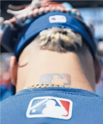  ?? DARRON CUMMINGS/AP ?? In this 2017 photo, the major league baseball logo is shown tattooed on MLB shortstop Javier Baez.