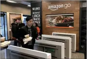  ??  ?? Shoppers at Amazon Go in San Francisco pass through the automated checkout in January.
